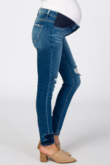 woman wearing dark blue maternity skinny jeans with distressed details and a stretchy over-the-bump panel, showing her baby bump