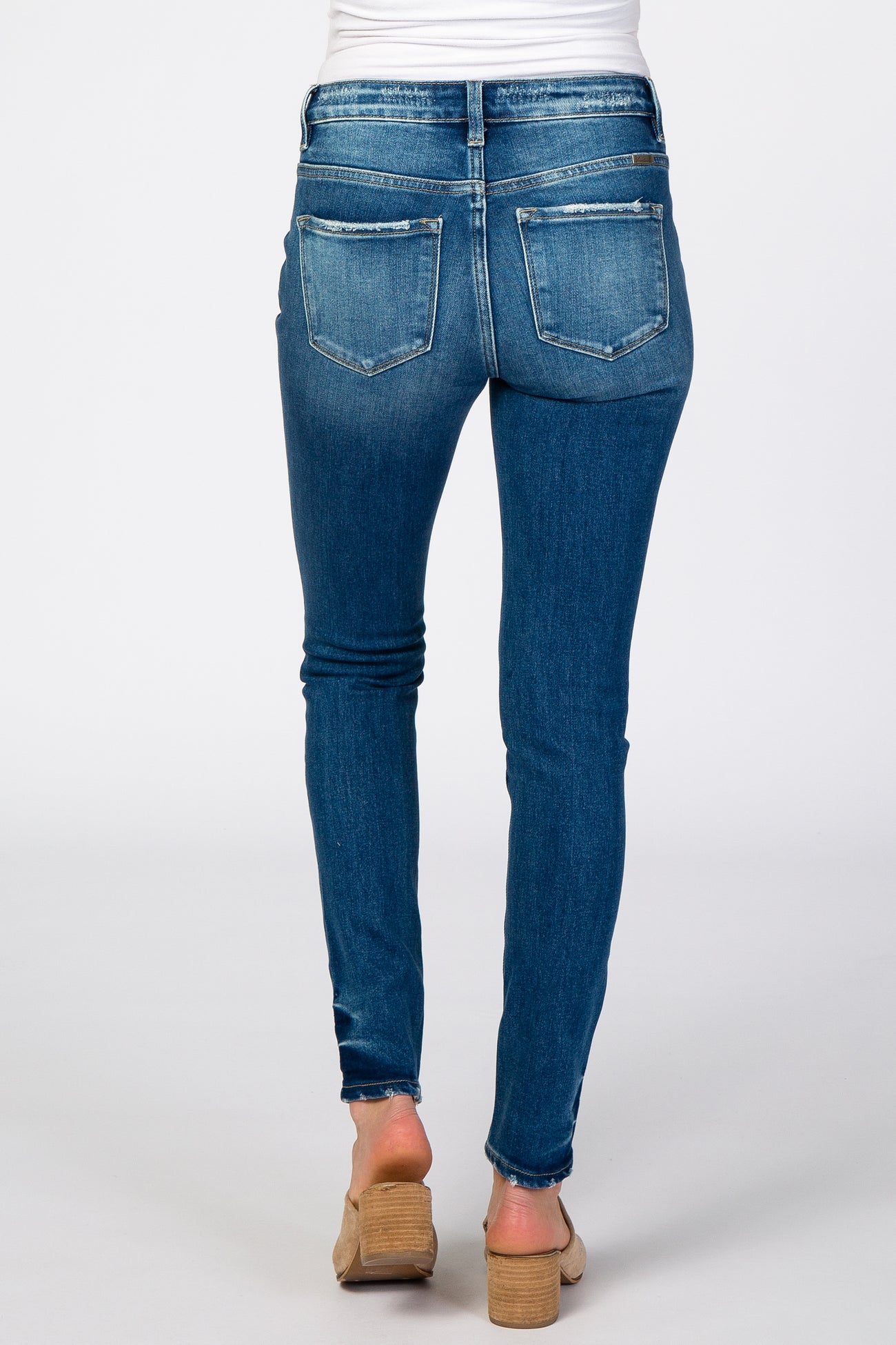 woman wearing blue maternity skinny jeans, showing the back view and a fitted style