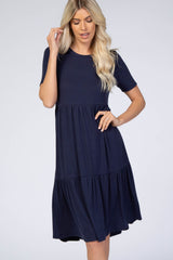 blonde woman wearing a navy blue short sleeve ribbed tiered maternity dress