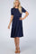 woman wearing a navy blue short sleeve tiered dress with a fitted top and flared bottom