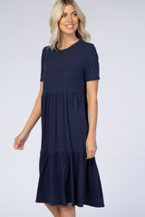 woman wearing a navy blue short sleeve tiered dress with a relaxed fit and a round neckline