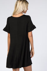 woman wearing a black short sleeve dress with ruffled sleeves, showing the back view
