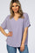 woman wearing a lavender v-neck short sleeve blouse and blue jeans