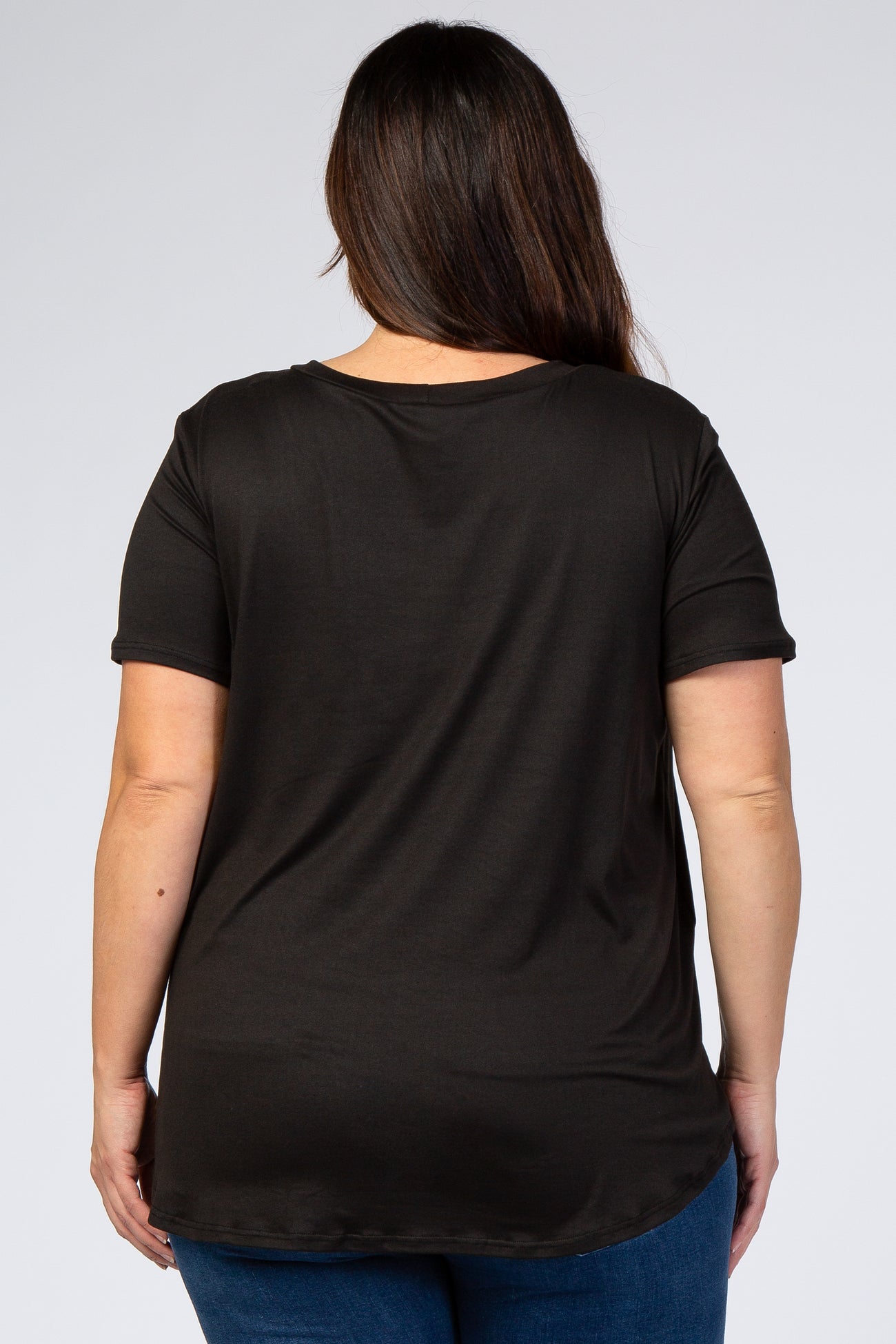 Back view of a woman with long brown hair wearing a basic black short sleeve t-shirt and blue jeans