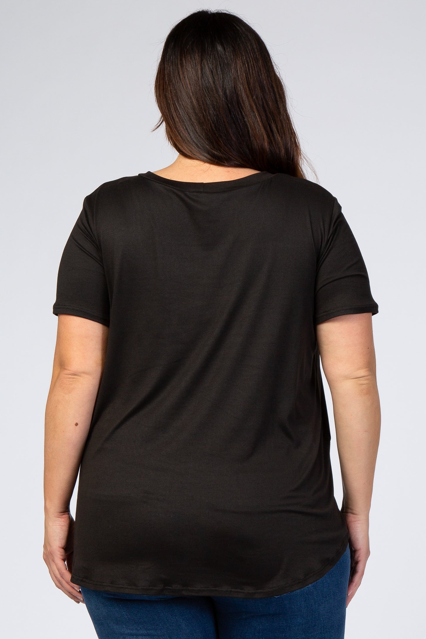 Back view of a woman with long brown hair wearing a basic black short sleeve t-shirt and blue jeans