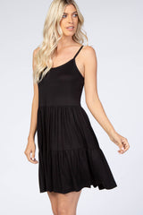 woman wearing a black sleeveless tiered mini dress with spaghetti straps