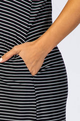 close up of a person's hand in the side pocket of a black and white striped dress
