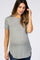 woman wearing a gray ribbed maternity t-shirt with short sleeves and a rounded hem, gently touching her hair and showing a baby bump