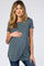 woman wearing a teal short sleeve maternity top and holding her baby bump