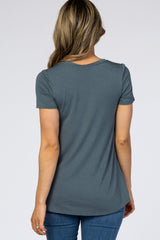 woman wearing a dark teal short sleeve top, shown from the back, with a relaxed fit and rounded hem