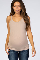 woman wearing a beige maternity tank top and showing her baby bump