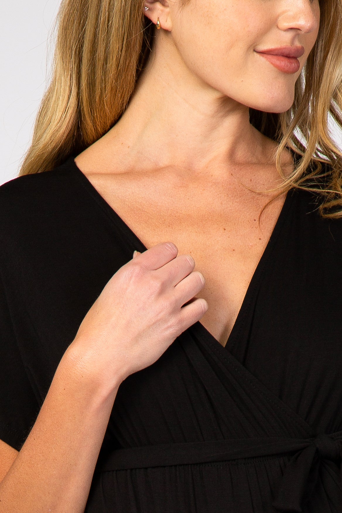 woman wearing a black short sleeve maternity wrap dress with a tie waist detail