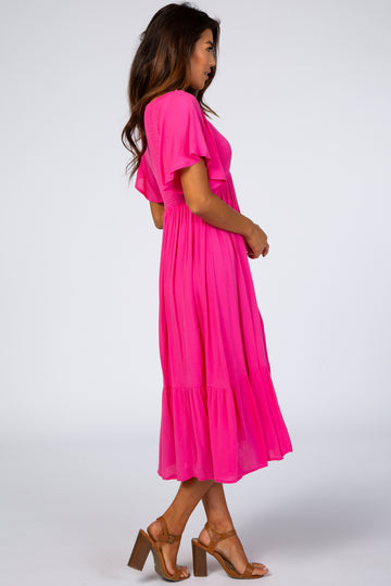 woman wearing a bright pink tiered midi dress with short sleeves and a flowing silhouette