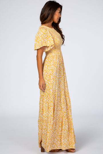 woman wearing a yellow floral maxi dress with flutter sleeves and a smocked bodice