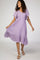 woman wearing a light purple short sleeve dress with a ruffled hem and a smocked bodice