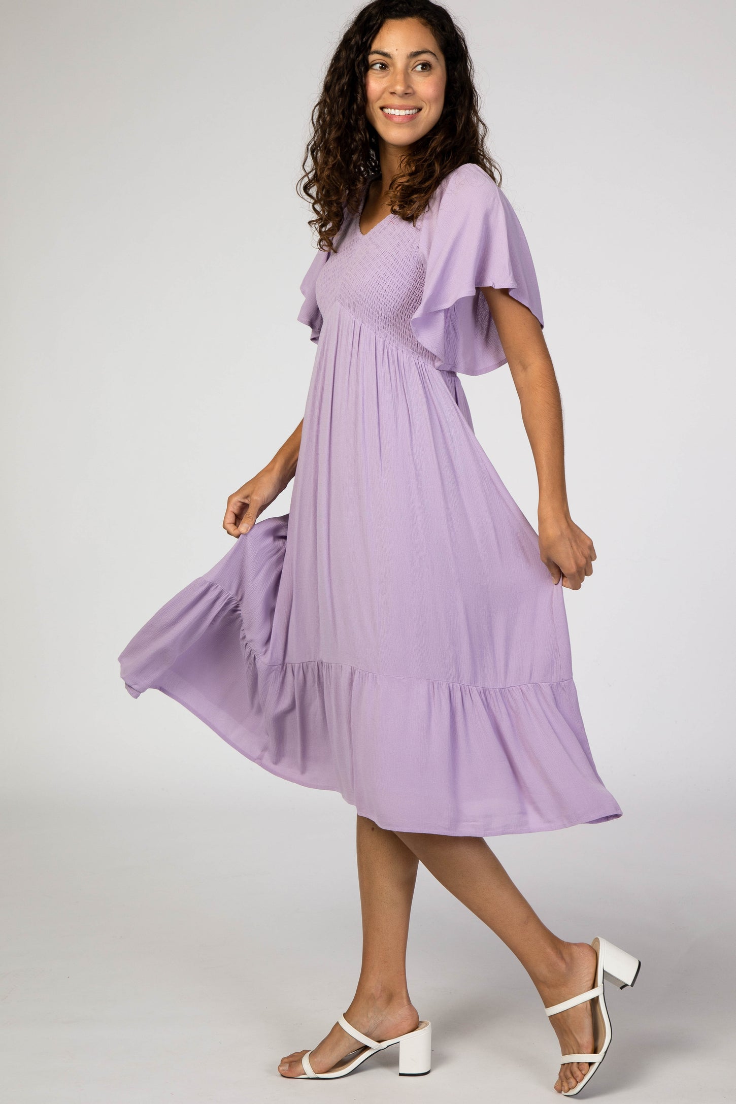 woman wearing a lavender v-neck short sleeve maxi dress with a tiered skirt and flowy silhouette