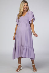 woman wearing a lavender maternity dress with flutter sleeves and a tiered skirt, showcasing a baby bump