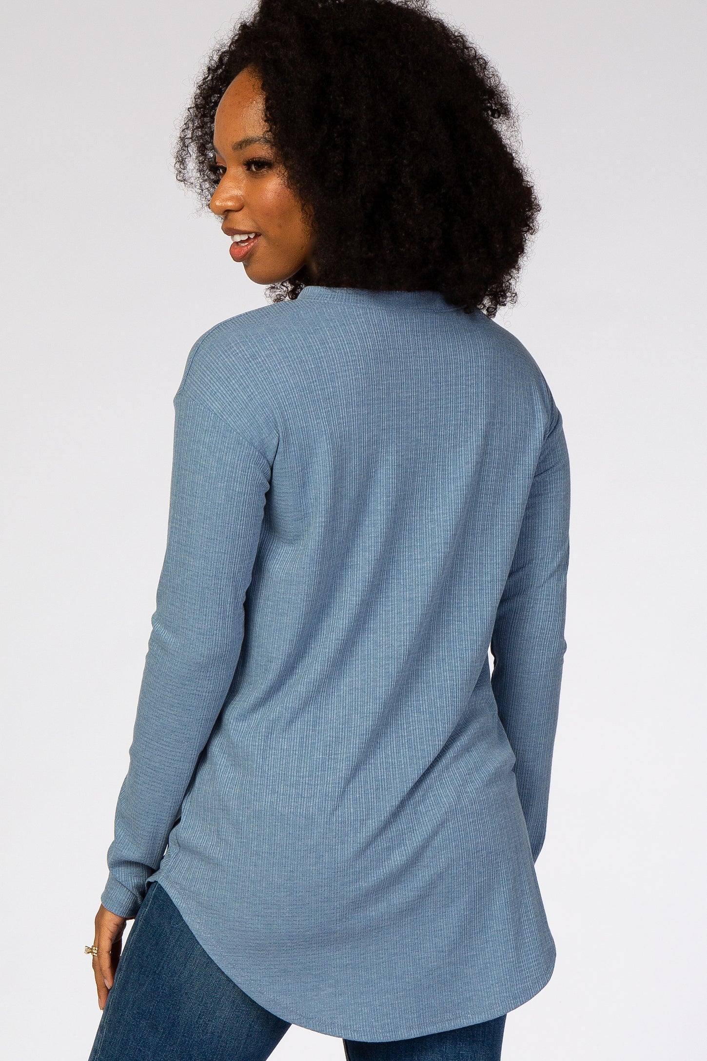 woman wearing a blue long sleeve ribbed knit tunic top from the back