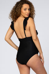 woman wearing a black maternity swimsuit with ruffle details and adjustable straps, showing the back view