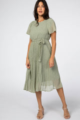 woman wearing a green floral midi dress with short sleeves and a belted waist