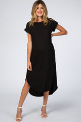 woman wearing a black maternity maxi dress with short sleeves and a high-low hem, showing her baby bump