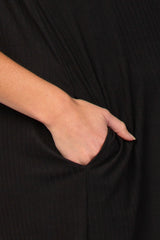 close-up of a hand in the pocket of a black maternity dress with vertical ribbed texture