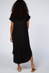 woman wearing a black oversized maxi dress with short sleeves and side slits, viewed from the back