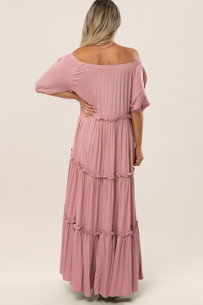 back view of a woman wearing a mauve off-the-shoulder tiered maxi dress with ruffle details