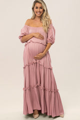 smiling pregnant woman wearing a pink off-the-shoulder tiered maternity maxi dress