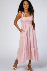 woman wearing a pink and white gingham tiered maxi dress with spaghetti straps and side pockets