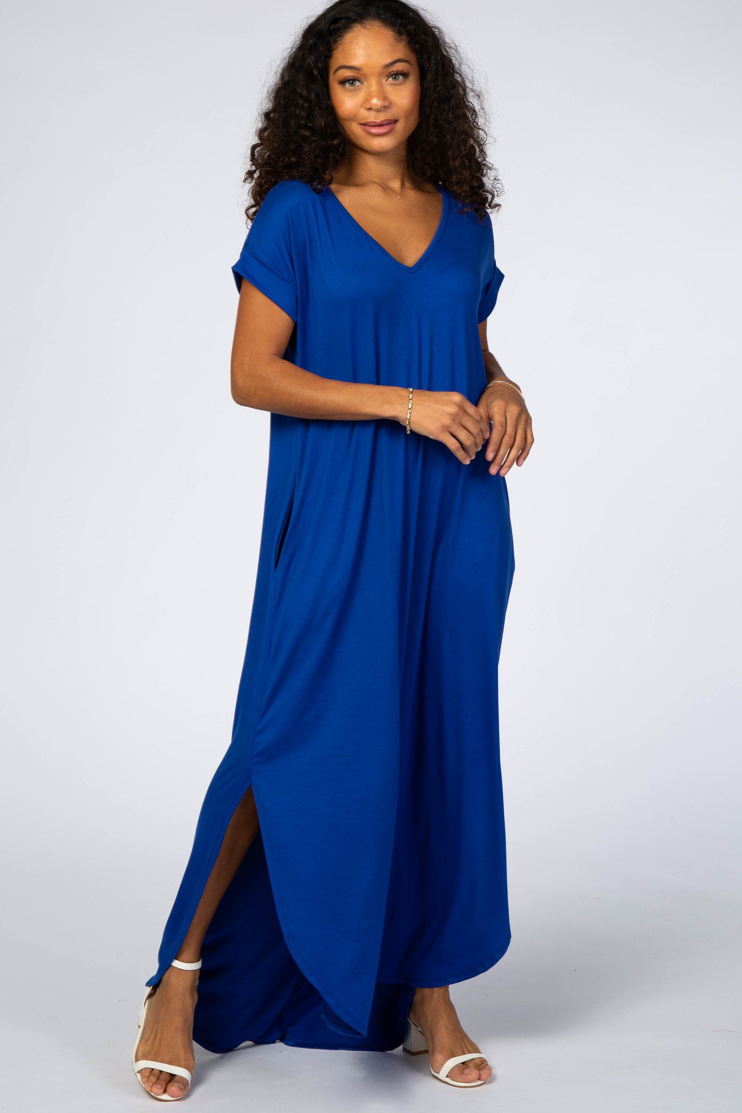 woman wearing a royal blue short sleeve maxi dress with side slits and a v-neckline