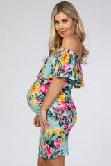 woman wearing a floral off-the-shoulder maternity dress showcasing her baby bump