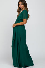 woman in a forest green short sleeve maternity maxi dress with a waist tie against a white background