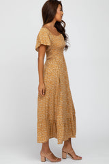 woman wearing a mustard yellow floral midi dress with a smocked bodice and short puff sleeves