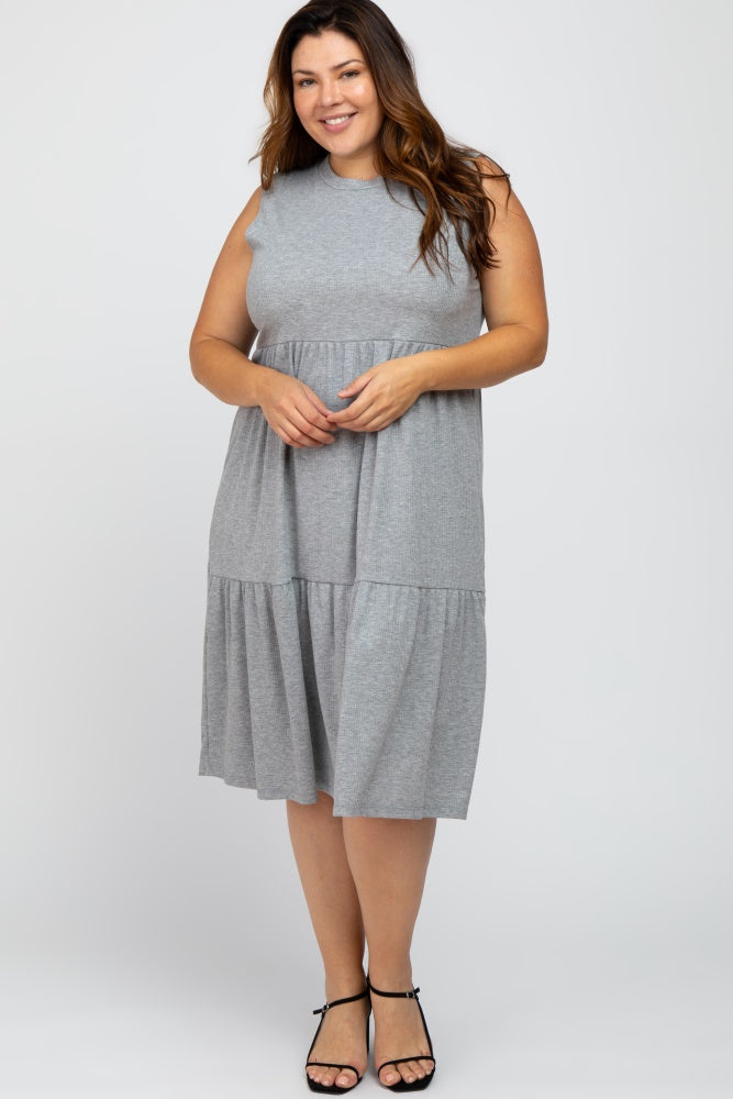 smiling woman wearing a sleeveless grey tiered midi dress and black strappy sandals