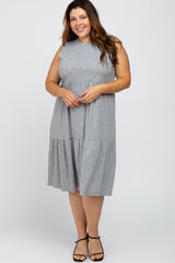 smiling woman wearing a sleeveless grey tiered midi dress and black strappy sandals