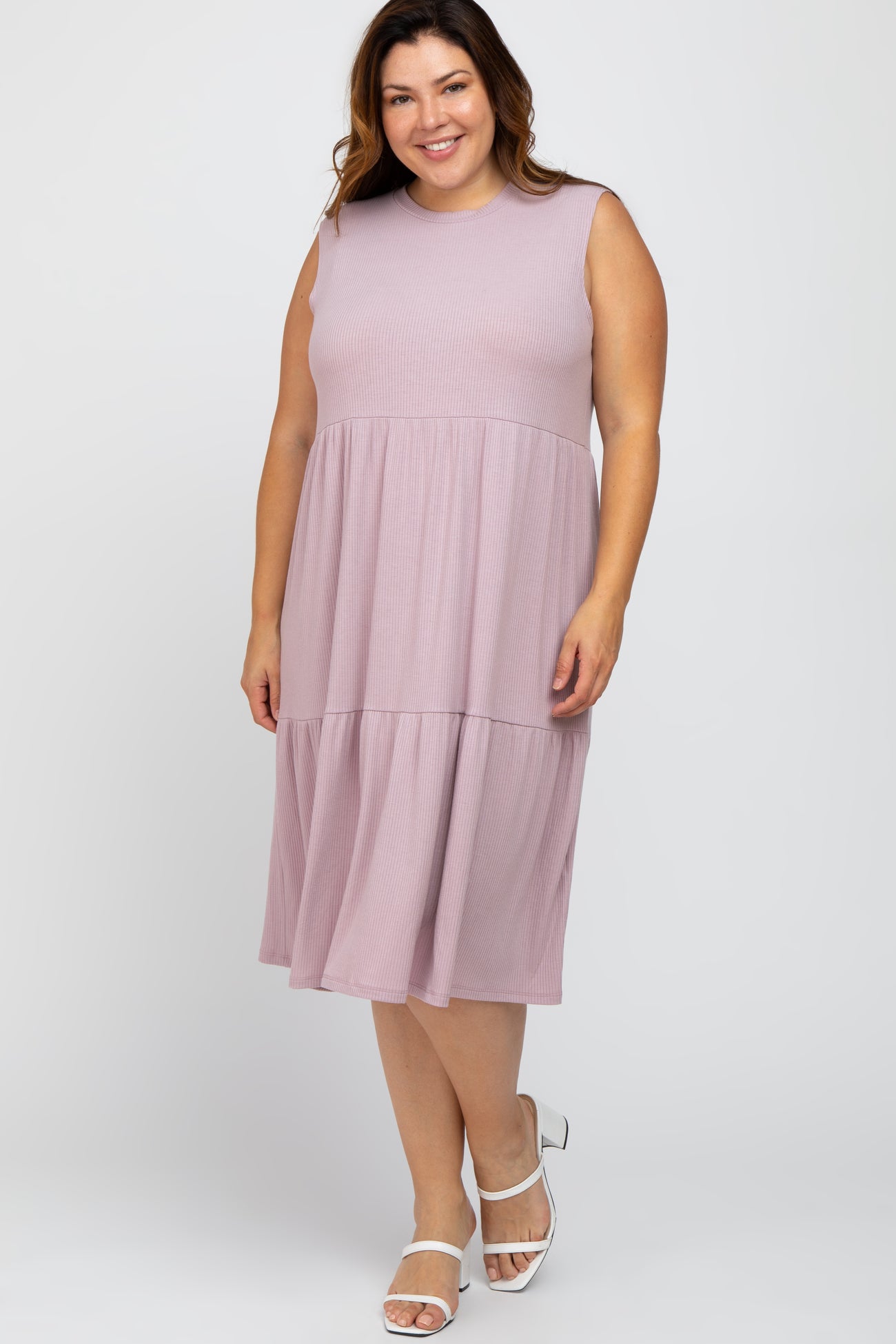 smiling woman wearing a mauve sleeveless tiered ribbed midi dress and white strappy heels