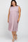 smiling woman wearing a mauve sleeveless tiered ribbed midi dress and white strappy heels