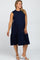 Smiling woman wearing a navy blue sleeveless tiered maternity midi dress and white block heel sandals