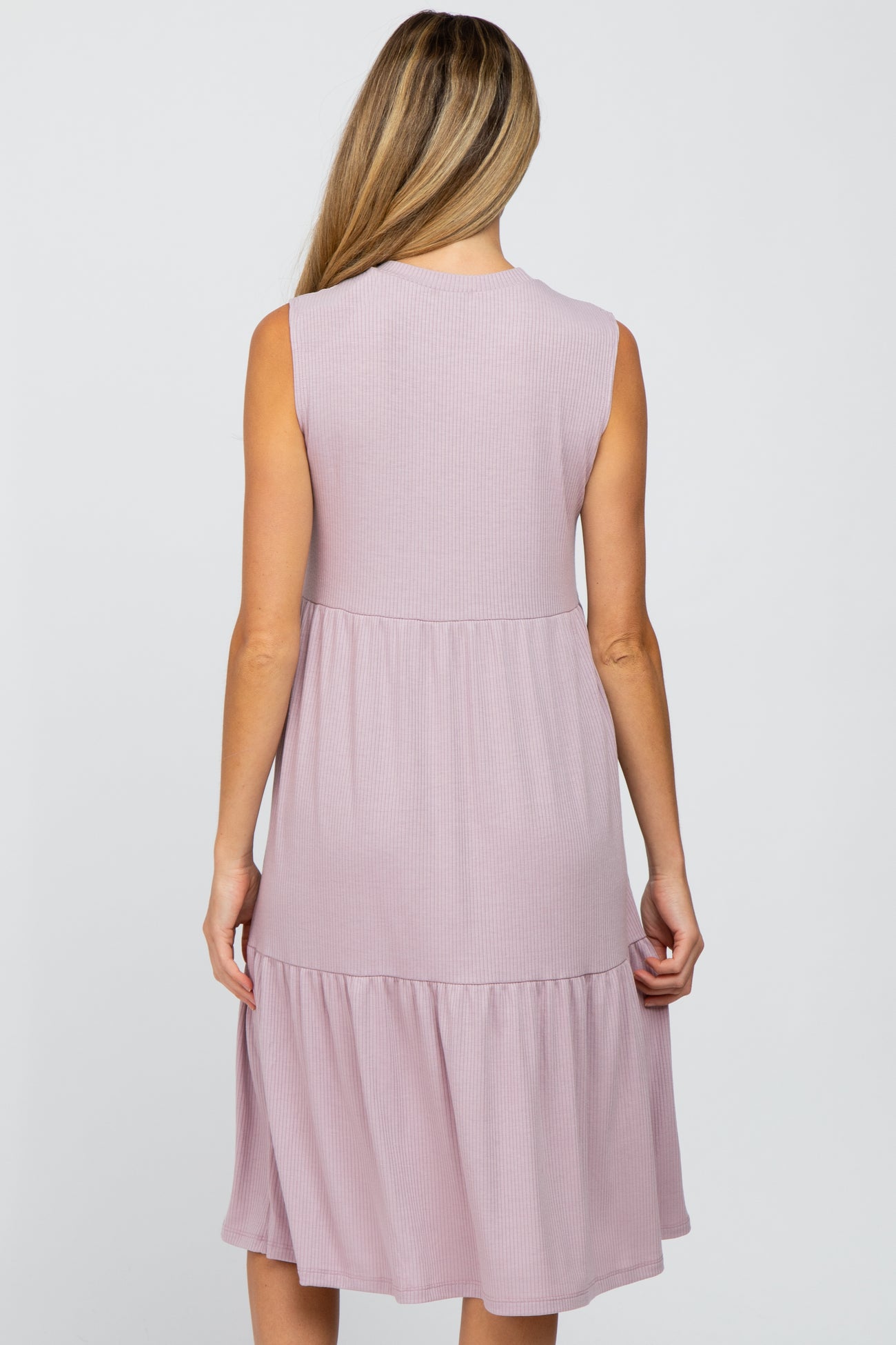 Back view of a woman wearing a mauve sleeveless tiered ribbed knit midi dress