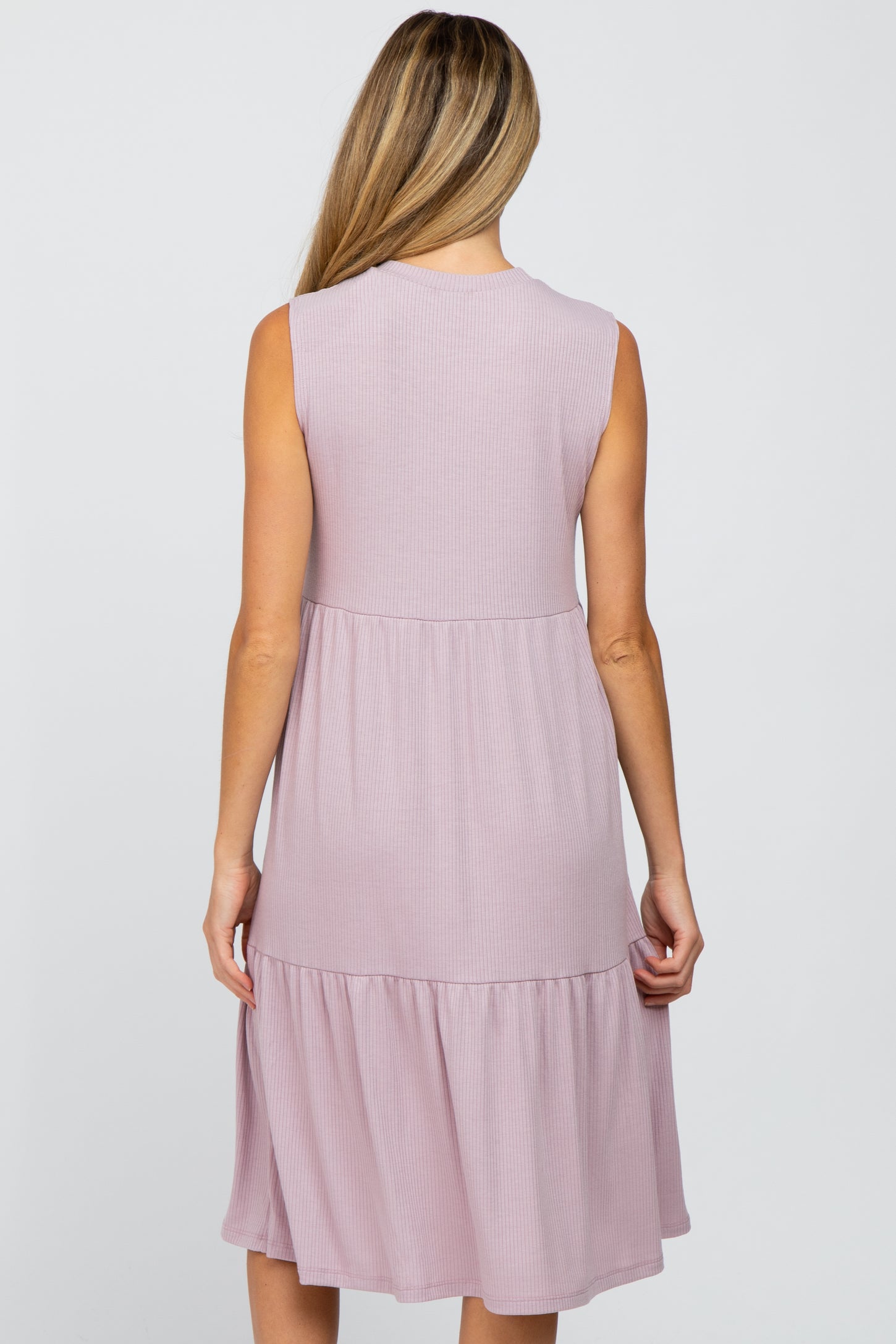 Back view of a woman wearing a mauve sleeveless tiered ribbed knit midi dress