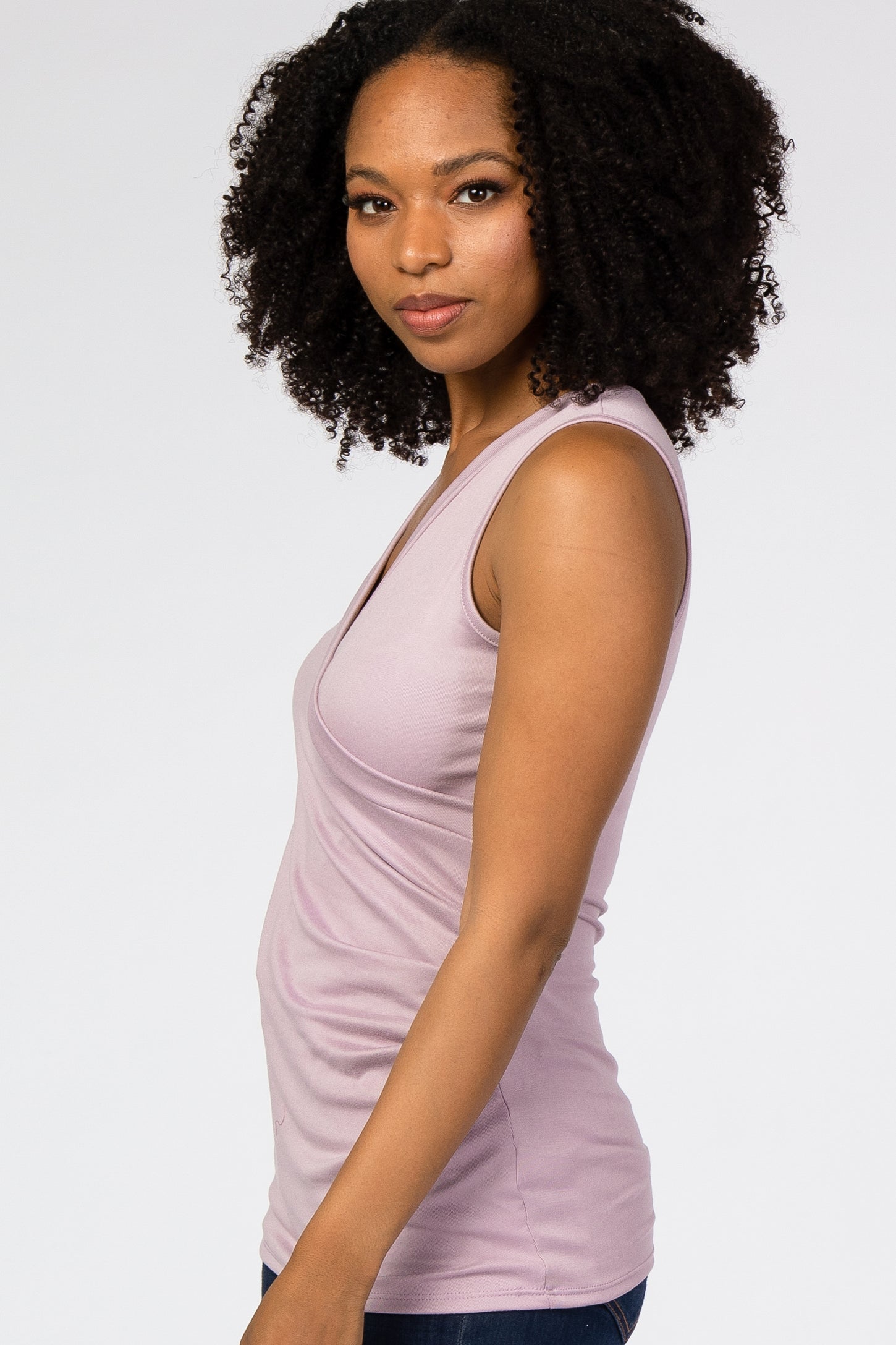 woman wearing a light purple sleeveless top with a v-neckline and fitted style
