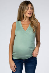woman wearing a light green maternity sleeveless top with a v-neck and a visible baby bump