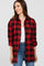 woman wearing a red and black plaid button-up shirt with rolled sleeves and a white tank top underneath