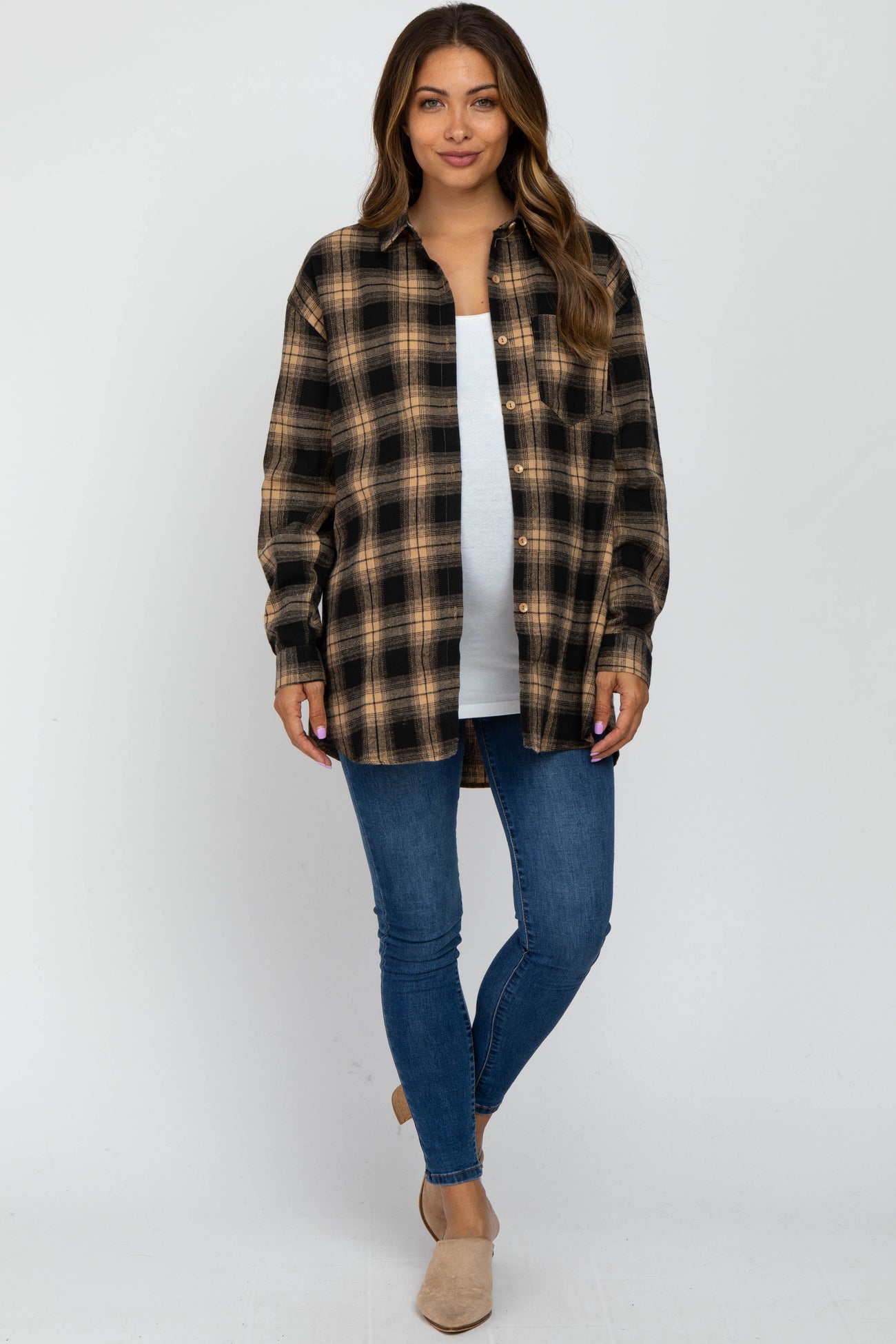woman wearing a black and tan plaid maternity shirt over a white top and blue jeans, with long hair styled down