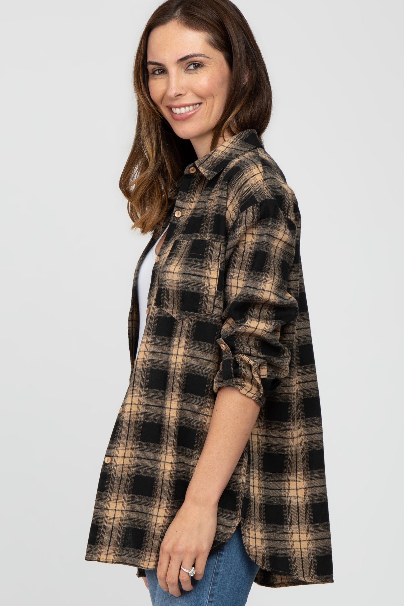 woman wearing a black and tan plaid button-up shirt with rolled sleeves and a relaxed fit