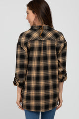 woman wearing a brown and black plaid flannel shirt, showcasing the back view and rolled sleeves