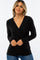 woman wearing a black long sleeve wrap top and smiling