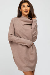 woman wearing a beige oversized cowl neck sweater dress with long sleeves and a relaxed fit