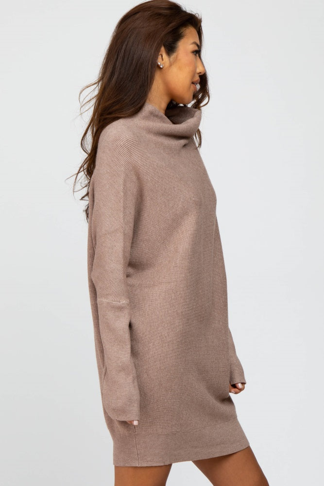 woman wearing a taupe oversized turtleneck sweater dress with long sleeves